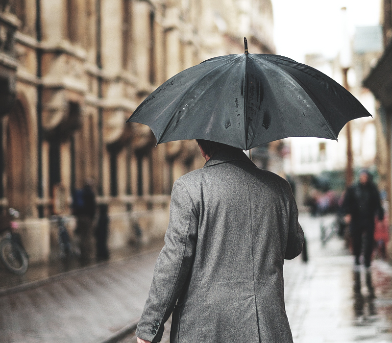 Ganthor AB - Man som går iväg med ett paraply, som symboliserar beredskap och skydd i försäkring